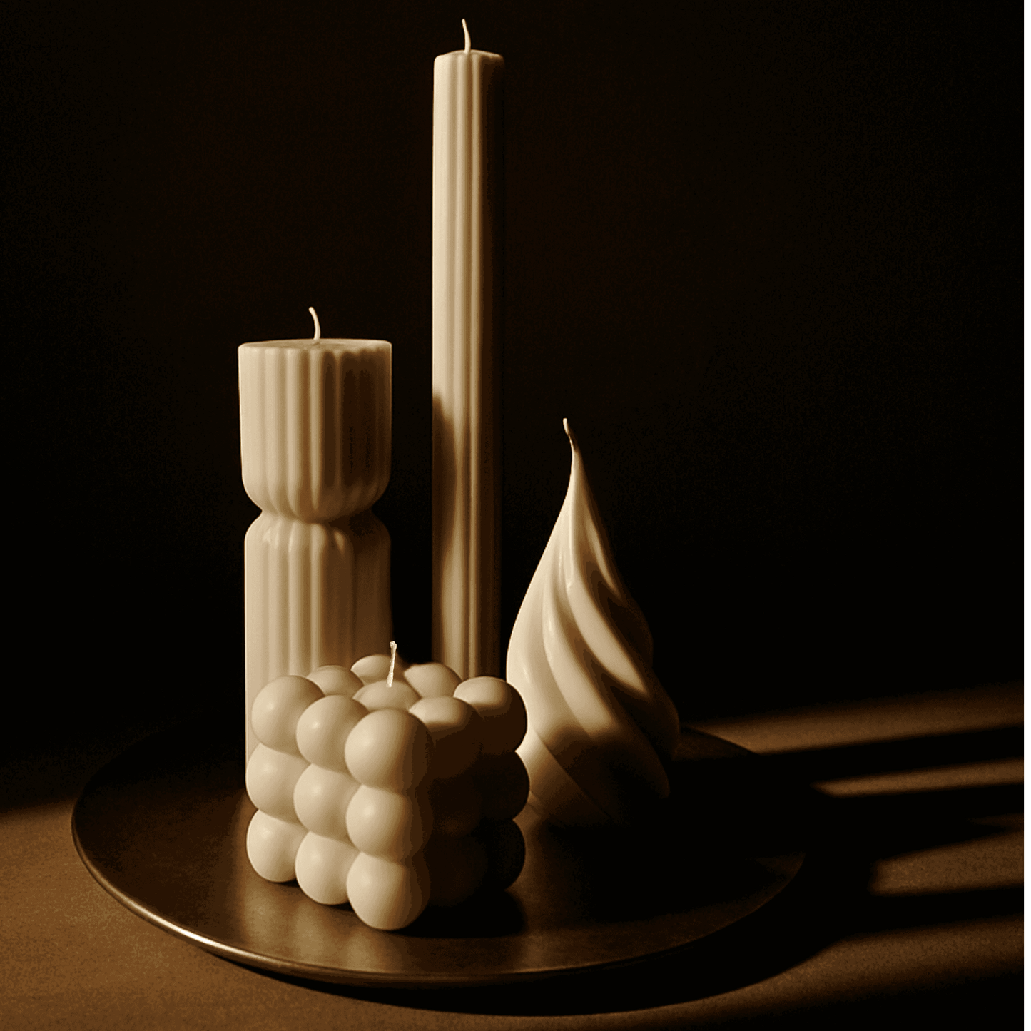 La Bouqe sculptural beige candles in various unique shapes displayed on a round tray