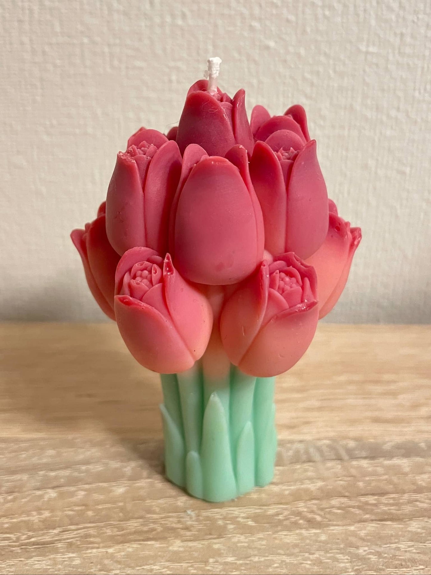 La Bouqe tulip bouquet candle with detailed red tulip flowers and green stems on wooden surface