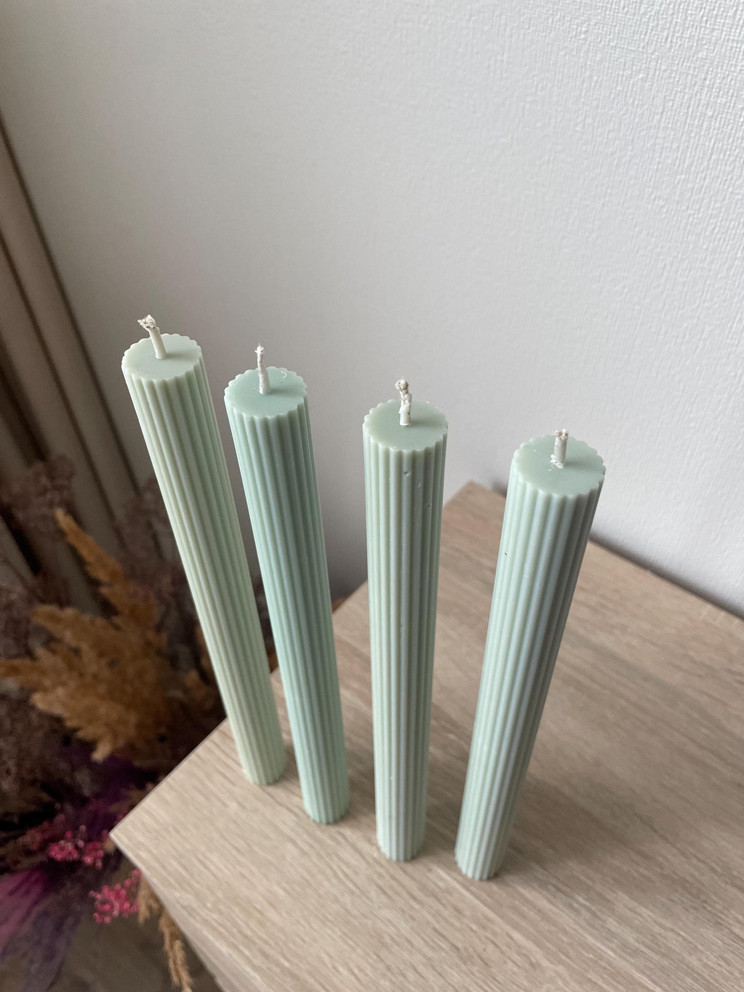 La Bouqe elegant dinner candles 4 pack in soft pastel green with ribbed texture on wooden surface