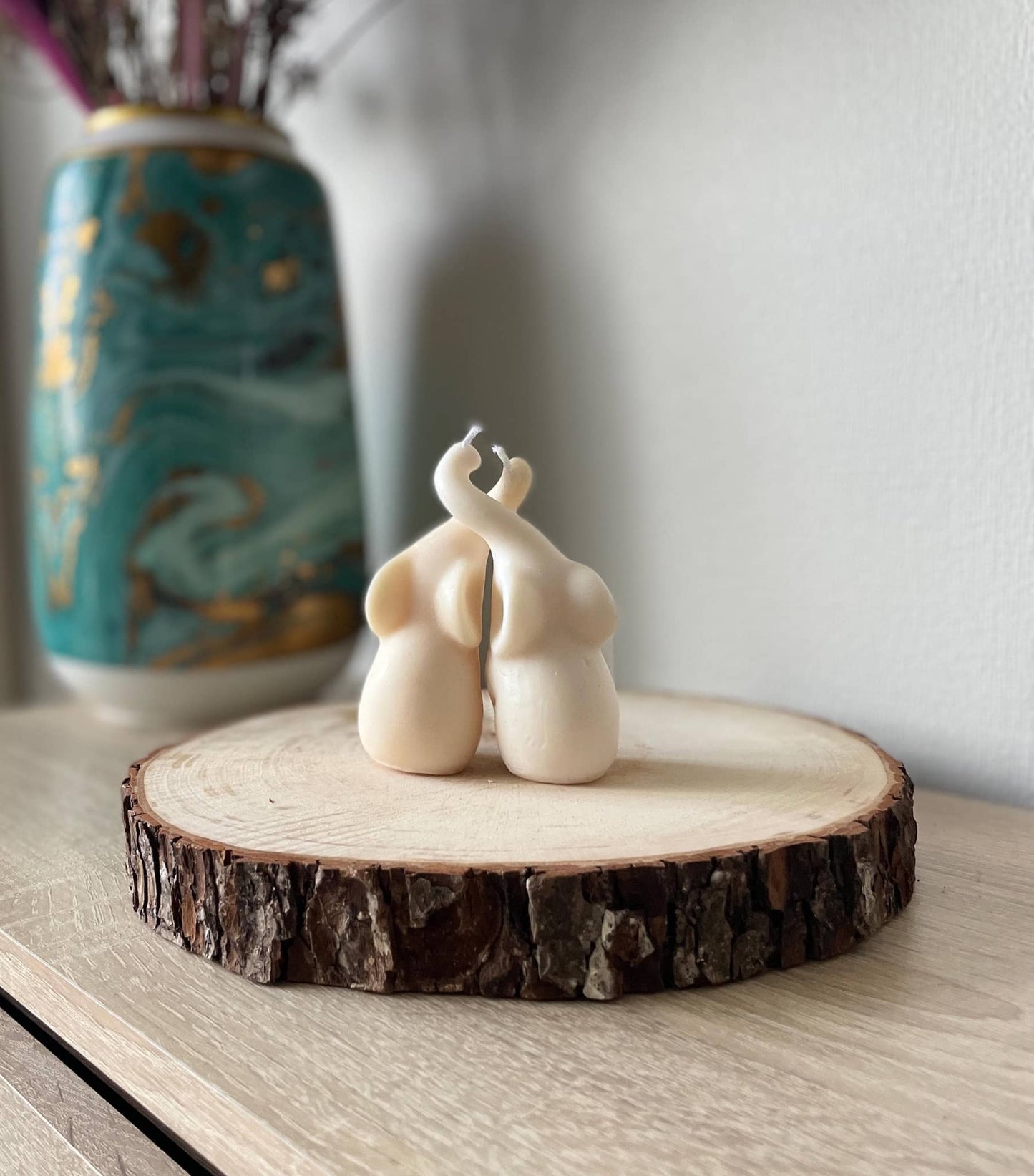 La Bouqe handmade elefant candle set in cream color displayed on a wooden slice with a decorative vase in the background