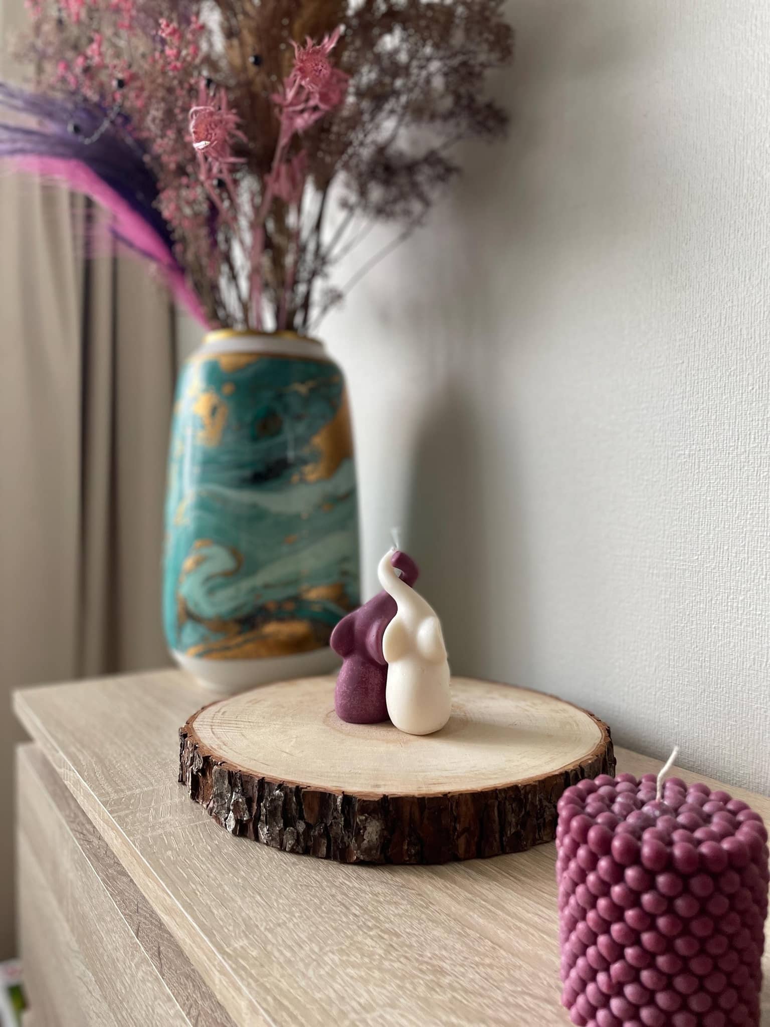 La Bouqe handmade elefant candle set in white and purple displayed on wooden slab with decorative vase and dried flowers
