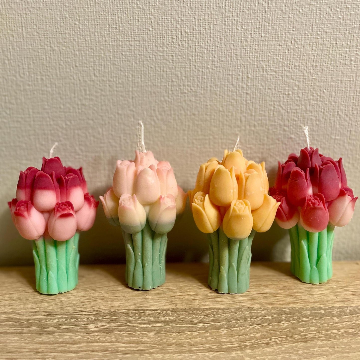 La Bouqe colorful tulip bouquet candle set with red, pink, and yellow flowers on wooden surface