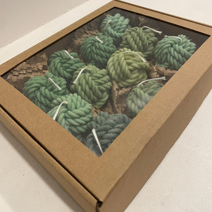 La Bouqe yarn ball soy candles in various shades of green packaged in a kraft box with a clear window