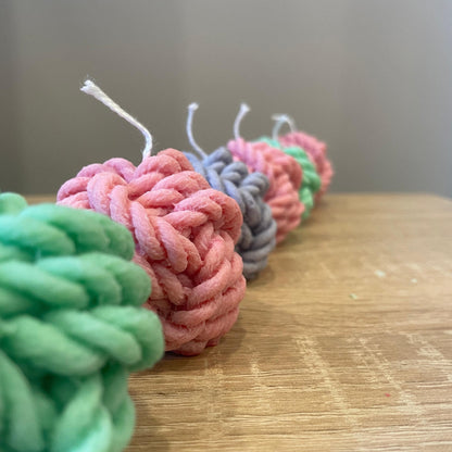 Colorful yarn ball soy candles in green pink and gray handmade by La Bouqe on wooden surface