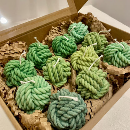 La Bouqe green yarn ball soy candles in various shades neatly arranged in a brown gift box with packing paper